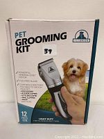 Front of box showing main clipper tool held in hand and description of included items and features