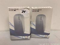 Two boxed wireless computer mice, grey color, front view of packaging showing mouse image and text 'Wireless Mouse'. Each includes a USB receiver as indicated by the seller.