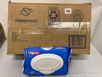 Eight sealed packs of Cottonelle flushable wipes in blue packaging with white lids, displayed with a cardboard box.