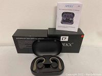 ApekX S7 wireless earbuds in charging case, original packaging and user manual booklet.