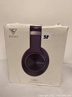 Front photo of the Doqaus Care 1 wireless headphones in original box showing product image and logo.