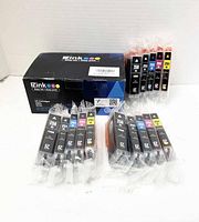 Photo of 15 EZ Ink compatible ink cartridges for Canon printers including black, cyan, magenta, and yellow. Each cartridge is individually sealed in plastic. The EZ Ink branded box is visible.