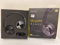 Front view of Kimitech headphones in foam packaging alongside product box showing branding and features