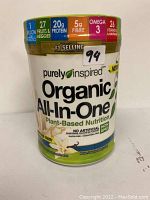 Front view of Purely Inspired Organic All-In-One protein powder container showing nutritional benefits and vanilla flavor.