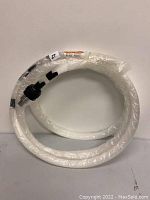 Coiled plastic optical fiber cable wrapped in plastic with a black capped end visible.