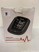 Front view of the Sinocare arm blood pressure monitor box showing the device and brand name on the packaging.
