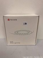 Front view of the box showing brand Teckin, model SL02 Smart Light Strip and simple drawing of light strip.