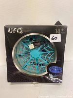 Photo of the front of the packaging showing blue UFO interactive aircraft toy with USB cable inside box.