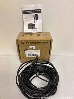 Wi-Fi Endoscope with coiled cable, user manual on top, and original box labeled "Wi-Fi Endoscope For iPhone,iPad,Android devices".