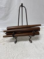 Four wooden tapered chair legs displayed on a stand, showing shape and finish condition.