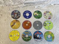 Childrens DVDs and VHS tapes discs laid out on crochet fabric background, showing titles like Curious George, SpongeBob SquarePants, and others