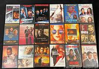 Photo showing 18 DVD cases laid out side by side in two rows. Covers include The Departed, Phone Booth, Space Cowboys and more.