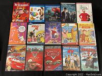 Photo showing a selection of 15 kids DVDs including The Incredibles, Hop, Brave, Harry Potter, Santa Clause, Pink Panther, Despicable Me, Sunny Days, Curious George, Cars, Toy Story, Pixar Cars, RV, How to Train Your Dragon.