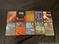 Photo showing ten live concert DVDs arranged on black surface with visible cover art including 2 Led Zeppelin shows, 2 Leonard Cohen performances, and others