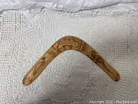 Top side view showing engraved kangaroo and Australia inscriptions on wooden boomerang