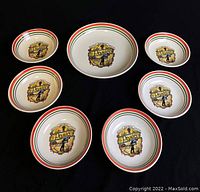 Top view of the full set showing one larger pasta dish and six smaller bowls with matching Italian-themed design and color stripes