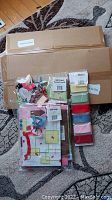 Three sets including gift bags, ribbons, and gift card pouches alongside two unopened boxes in the background.