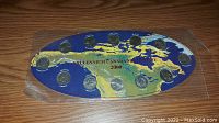 Sealed set of 12 Canadian quarters from 2000 Millennium Edition arranged on a blue and yellow map of Canada.