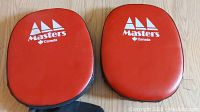 Pair of red hand held punch pads with 'Masters Canada' logo shown from front side including wrist straps.