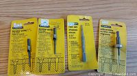 Photo showing four items in yellow and blue retail packaging: 3 Stanley screw sinks for triple usage and 1 Sey nail set 2/32" (1.6 mm).