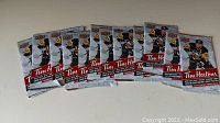 12 unopened packs of 2015-16 Tim Hortons hockey cards featuring Sid Crosby on the front, arranged in two rows on a surface.