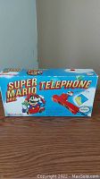 Front view of original box showing Bondwell Super Mario Bros Telephone branding and image of red phone with Mario figurine on handset.