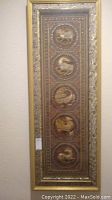 Full view of large vertical Asian wall art with gold frame and five circular animal relief panels.