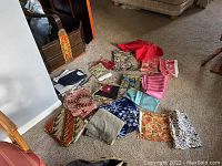 Overview photo showing all 12 assorted fabric pieces spread on carpeted floor, various colors and patterns visible.
