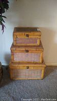 Three bamboo nesting chests stacked on each other showing front and side views, natural bamboo color with locks.