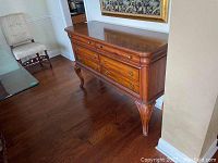 Side angle showing the full buffet with six drawers, polished wood surface, and carved legs