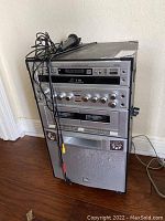 Full view of the karaoke machine tower with attached microphone and wires on floor.