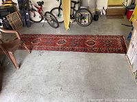 Full view of the long runner rug stretched out on concrete floor showing size and color.