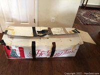 Closed, taped Holiday Time cardboard box labeled for artificial Christmas tree storage and shipping.