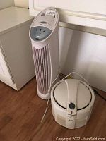 Honeywell tower fan and Honeywell air purifier placed on floor side by side.