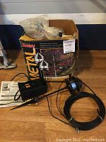 Full set of Malibu Metal low voltage landscape lights with original box, transformer, cables and light fixtures shown on wood floor.