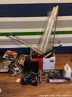 Full overview of the painting supplies and tools including rollers, trays, plastic sheets, and long handles.