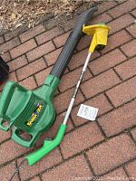 Full view of green Weed Eater Barra CUDA Super Blower with attached black blower tube and green handle, next to yellow trimmer attachment.