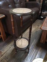 Full view of the cane stand showing its structure, four legs, and two cane-inserted circular shelves.