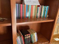 Books arranged on wood shelves showing multiple rows of children's books including full set of A Series of Unfortunate Events and Pendragon series, with visible wear and used condition.