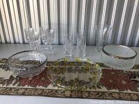 View of all seven crystal pieces on decorative table runner, including bowls, glasses, and vases