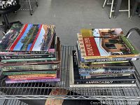 Photo showing two stacks of hardcover books with titles visible on spines, mostly related to architecture and design.