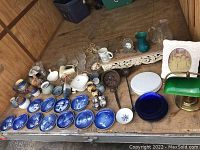 Overview photo showing all items including plates, pitchers, lamp, ladles, and glassware arranged on wooden surface.