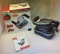 Photo shows the Homedics TherapistSelect Ultra deep tissue massager in silver and black with power cord, original packaging box indicating heat function, and user manual booklet.