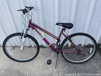 Full side profile of the purple Roadmaster Granite Peak mountain bike showing frame, tires, seat, and pedals.