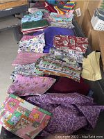 Photo showing various fabric bolts laid out with colorful patterns including cartoon animals, stars, and swirls.