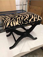 Side-angle view of zebra pattern bench stool chair showing the cushion and wooden frame design.