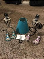 Pair of two novelty lamps with human foot bases in purple and blue, showing entire lamps and cords