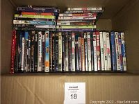 Photo of a large box containing mixed DVDs and Blu-rays arranged vertically showing titles like Gladiator, Red Dawn, and others.