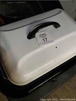 Outer white lid with black handle of Hamilton Beach roaster oven