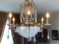 Frontal view of assembled chandelier hanging with bulbs illuminated